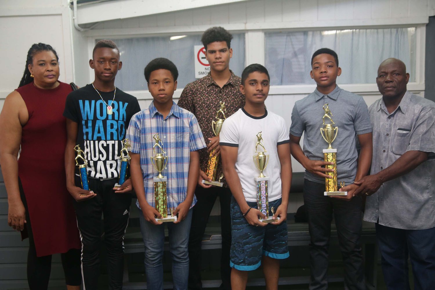  From left, Dawn Layne, Jamaal Nicholas, Terrence Rausch, Vincente Henery, Niron Bissu, Isaiah Layne and Mikey Layne with some of the trophies won. (Keno George photo)