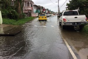 A taxi driving through flooded First Street 