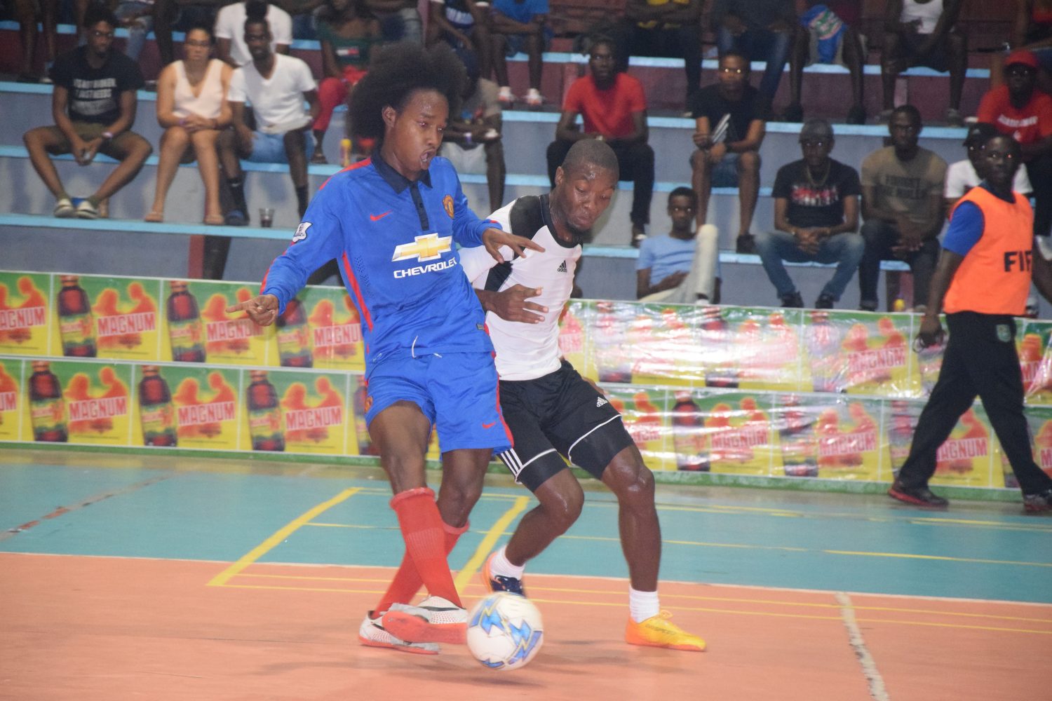 Travis Lyken (left) of Bent Street, attempting a pass, while being challenged by Dexroy Adams of Showstoppers, during their quarterfinal clash at the National Gymnasium in the Magnum Mash Futsal Championship 