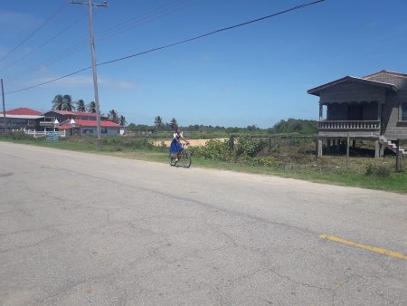 A school girl pedals home for lunch. 