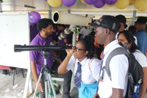 Students of the St. Joseph High School testing a telescope at the Faculty of Natural Sciences booth yesterday during the University of Guyana’s annual Open Day at the Turkeyen Campus. (Photo by Keno George)
