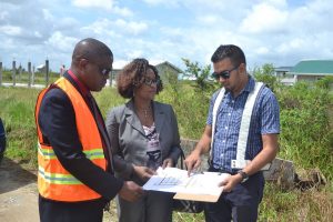 Lelon Saul, CH&PA CEO (left), Denise King-Tudor Director of Operations (centre) and Omar Narine, Director of Projects examine a plan of infrastructural works to be carried out in Lust-en-Rust, Parfaite Harmonie, West Bank Demerara. (See story on page 18)  (Department of Public Information photo)  