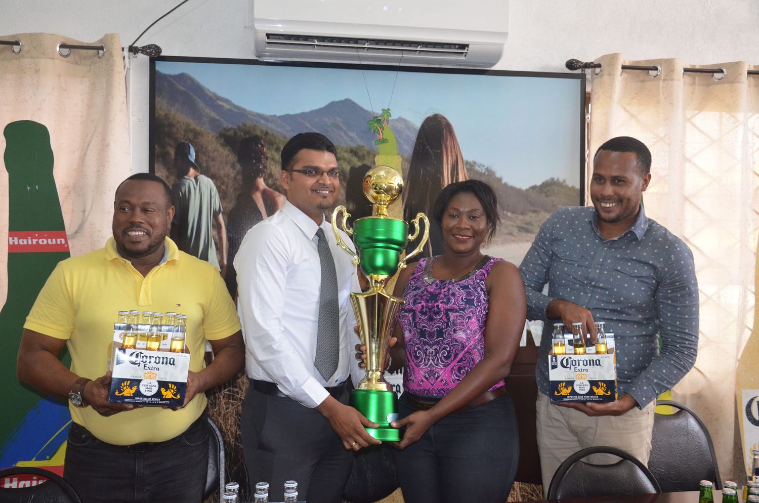 Sales Manager Rishi Rampersaud handing over the championship trophy to Petra Organization representative Jacklyn Boodie, in the presence of Petra Co-Director Troy Mendonca (left) and Marketing and Promotions Manager Marvin Wray (right)