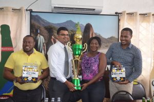 Sales Manager Rishi Rampersaud handing over the championship trophy to Petra Organization representative Jacklyn Boodie, in the presence of Petra Co-Director Troy Mendonca (left) and Marketing and Promotions Manager Marvin Wray (right)