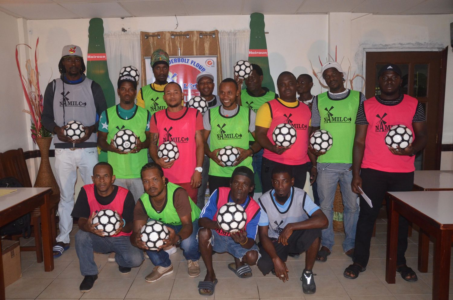 Players and representatives from several of the competing teams, displaying their practice balls and playing bibs for the Corona Futsal Championship