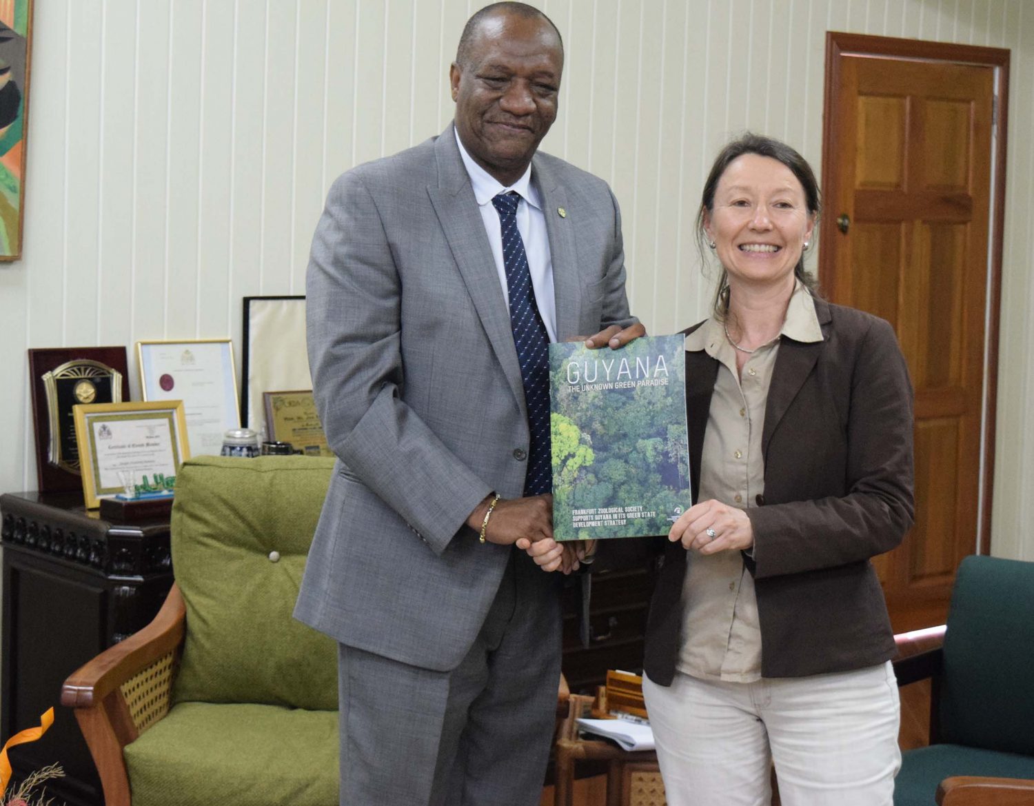 Minister of State, Joseph Harmon was presented with a book on the Frankfurt Zoological Society’s support for and work in Guyana.  (Ministry of the Presidency photo)

