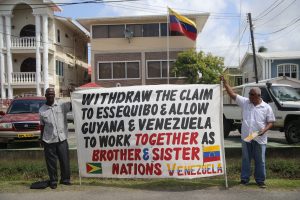 Withdraw claim: Activist Don Gomes (right) and his friend yesterday held a  protest in front of the Venezuelan Embassy on Thomas Street calling for Venezuela to withdraw its claim to Guyana’s  Essequibo. 