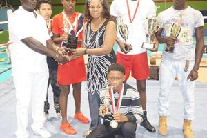 Winner’s Row! The best boxers, Deeron Williams (school boy best boxer), Ravin Rodrigues (junior best boxer), Chris Moore (youth best boxer) and Alisha Jackman (female best boxer) and Colin Lewis pose for a photo with promoter, Alford McDonald and sister of Patrick Forde, Joy Massay.