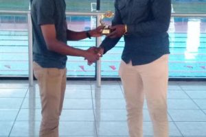 Anthony Drayton is seen receiving his trophy recently from President of the Guyana Chess Federation James Bond at the Aquatic Centre, Liliendaal. Drayton won the strong National Senior Qualifier Chess Tournament and is a favourite to win the 2018 National Chess Championship. He won the inaugural Caribbean Chess Cup in December in Barbados.
