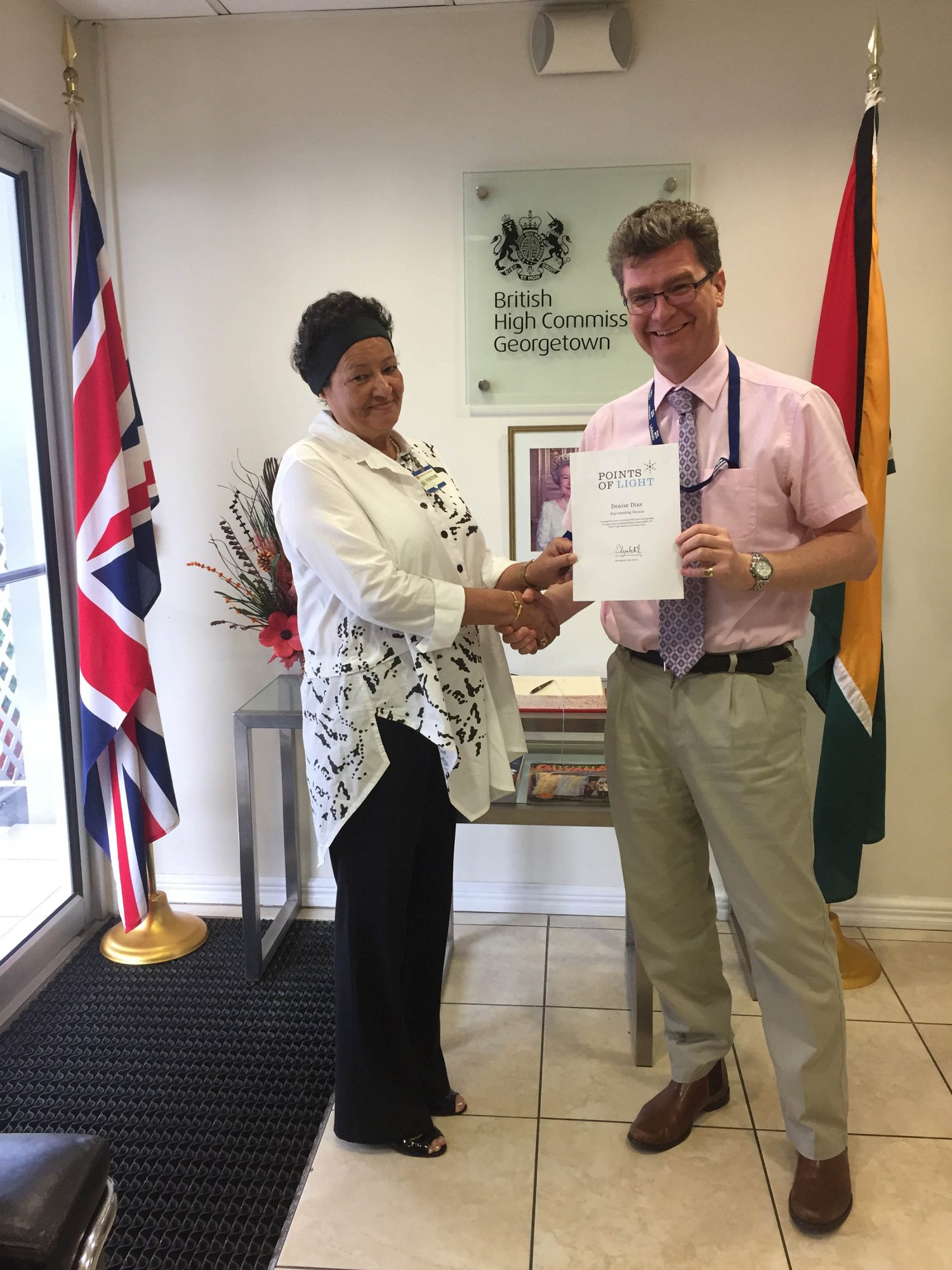 Denise Dias (left) being congratulated by British High Commissioner, Greg Quinn.