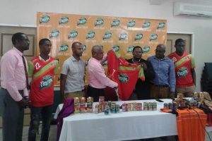Samuel Arjoon (third from right), Commercial Manager of GBI, hands over the symbolic jersey to Fruta Conquerors Assistant Secretary/Treasurer Jolyan Lewis, in the presence of several members of the club and company. From left to right-Club Secretary Daniel Wilson, player Nicholas MacArthur, Club Vice-President Colin Gittens, Andre Noel, Category Manager Juices, SM Jaleel and Player Jeremy Garrett.