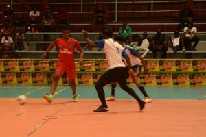 Eon Alleyne (left) of Team Extreme, attempting to initiate an attacking move, while being watched closely by Showstoppers players in the Magnum Mash Futsal Championship at the National Gymnasium