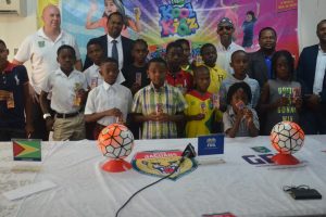 FIFA Regional Director Marlon Glean (2nd from left), GBI Commercial Director Samuel Arjoon (2nd from right), GFF Technical Director Ian Greenwood (left) and GFF President Wayne Forde (right) pose with several participants at the launch of the GFF/Kool Kidz Grassroots Programme yesterday.