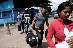 Venezuelans walk to show their passports or identity cards at the Pacaraima border control, Roraima state, Brazil November 16, 2017.  REUTERS/Nacho Doce