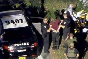 A man placed in handcuffs is led by police near Marjory Stoneman Douglas High School following a shooting incident in Parkland, Florida, February 14, 2018 in a still image from video. WSVN.com via REUTERS