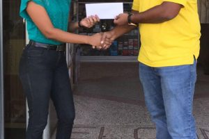 Darshini Narine (left) hands over the sponsorship cheque to Parmanand Persaud.