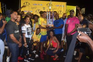 Three Peat-Captain Marvin Josiah of Showstoppers collects the championship trophy from Colours Director Robeson Brotherson after they defeated ESPN in the final of the Guinness ‘Greatest of the Streets’ West Demerara/East Bank Demerara zone at the Pouderoyen Tarmac Friday