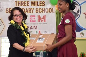 First Lady,  Sandra Granger (left) presenting a robotics kit to a representative of the Three Miles Secondary School. (Ministry of the Presidency photo)