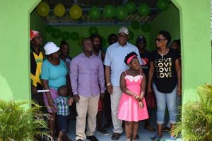 Minister of Finance Winston Jordan (wearing hat) with Wismar residents in a  newly constructed bus shed.  (DPI photo)