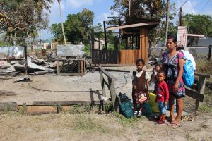 Verneta Ossorio and three of her children standing in front their burnt house yesterday.