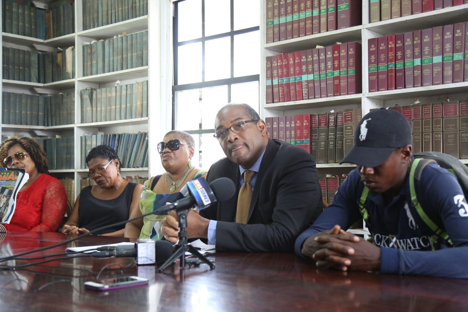 Attorney Nigel Hughes (second, from right) flanked by Devon Lyte (at right) and the sisters of Dextroy Cordis during the press conference yesterday.