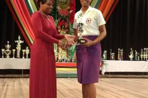 Romelia Hughes receives her winning trophy after her submission was adjudged the best entry for the Mash 2018 Republic of Guyana Essay Writing Competition.