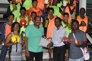Diamond Upsetters FC President Andre Fortune (2nd right) receiving the equipment from Ralph Green (2nd from left) in the presence of club Secretary Ms. Hazel Ferdinand (left), Treasurer Flacton Hendricks (right) and players