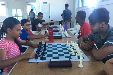 The Guyana Chess Federation hosted a Mashramani Blitz Chess Tournament recently at the National Aquatic Centre, Liliendaal. Blitz is usually referred to as speed chess and during blitz games, each player has five minutes on his/her timer to complete the game. In the photo Cassandra Khan (left) faces Saeed Ali. Khan was adjudged the best female junior chess player of the competition, while Ali, who qualified for the National Senior Chess Championship, is playing today at the Windjammer Hotel in Kitty.