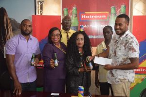 President of the Georgetown Dominoes Association (GDA) Faye Joseph receives the sponsorship from a representative of Top Brandz recently.