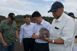 Minister of Natural Resources Raphael Trotman (right) examines the manganese mineral with Steven Ma (second from right), Assistant General Manager of Bosai’s Overseas Department and Chinese Ambassador to Guyana Cui Jianchun (third from right.) (DPI photo)