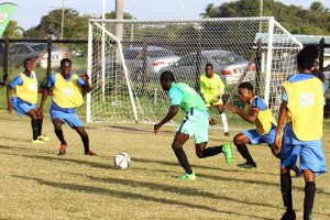 Stephon Reynolds (centre) of Chase Academy is surrounded by several players from Sir Leon Lessons, during their quarter-final clash at the Ministry of Education ground, Carifesta Avenue in the 6th Milo Secondary Schools Football Championships. (Orlando Charles photo)