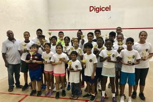 Participants in the recently concluded Toucan Distributors Junior Skill Level Squash Championship, pose with their spoils alongside Junior National Coach Carl Ince
