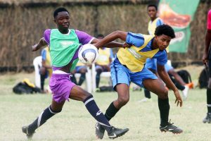 Zion Gray (right) of Sir Leon Lessons tussling with his Lodge Secondary marker at the Ministry of Education ground, Carifesta Avenue semi-final in the Milo Secondary School U18 football championships. (Orlando Charles photo