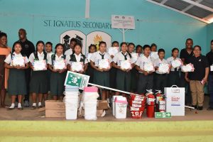 From left: Headmistress of the St. Ignatius Secondary School, Yvette Archer; acting Director General of the CDC, Lieutenant Colonel, Kester Craig; students who participated in the project and Volunteers of the CDC, with the donated items. (Ministry of the Presidency photo)