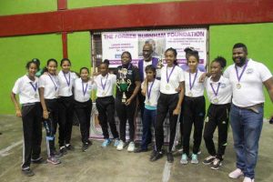 Mae’s Secondary School girls team with MVP Afruica Gentle (black) and Vincent Alexander, President of the Forbes Burnham Foundation.
