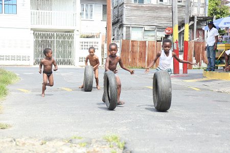 Tyre race: Children racing tyres at George and Leopold streets yesterday as a parent looks on. (Terrence Thompson photo)Keeping it clean: Trench clearing at Homestretch Avenue yesterday. 