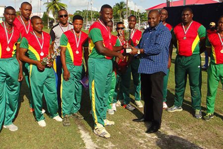 The Guyana Defence Force skipper Leon Andrews (left center) receives the Balram Raghubir Inter-Service T/20 championship trophy.
