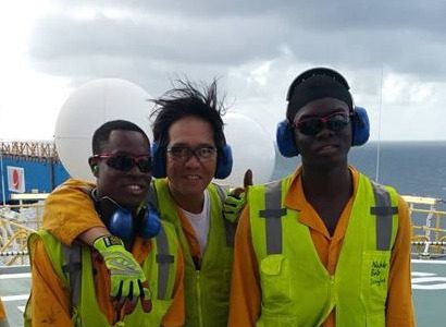 Two of the Guyanese crew members pose with a friend atop the Noble Bob Douglas’ heliport.