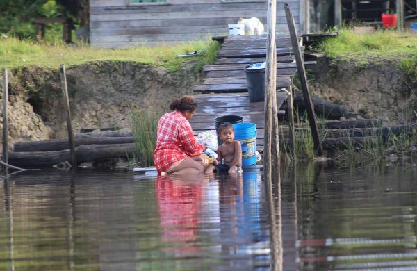 A resident about to do her laundry, while the little one holds his toothbrush