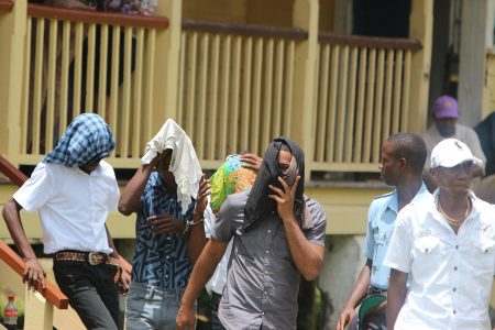 Some of the accused  being escorted out of the Providence Magistrate’s Court yesterday. From left are Mark Prince, Mervin Blackman, Edward Skeete and Renhart Khan.