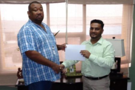 BCB President Hilbert Foster receives the sponsorship cheque from Kelvin Singh- Ansa McAl’s Divisional Head of Food and Consumer Products.