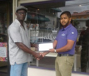 Sales Manager of Hallmark Guyana, Stephan Ramroop (right), a subsidiary of C&L Construction Inc., hands over their support to Colin Boyce yesterday.