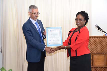 Minister of Business, Dominic Gaskin hands (left) over ISO9001:2015 certificate to the Candelle Walcott-Bostwick, Director of GNBS. (DPI photo)