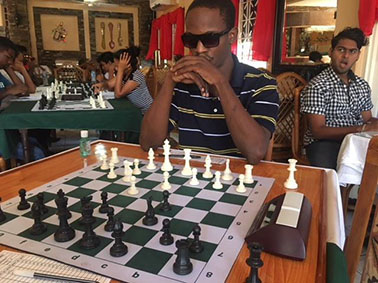 Contemplating his next move: Wendell Meusa played undefeated to win the 2018 Senior National Chess Championship recently. Meusa entered into a playoff with Anthony Drayton to decide who would be the National Champion. Meusa won handsomely in the two best-in-three playoff. In the background is Saeed Ali, one of the participants of the National Championship.