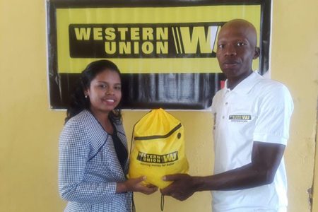 Walter Grant-Stuart receives the sponsorship from Grace Kennedy Guyana Limited Marketing Assistant, Tina Seabra.
