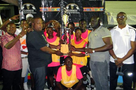 Uprising captain  Phillip Williams (centre) collects the championship trophy following his side’s 3-0 win over Paradise-A in the final of the Guinness ‘Greatest of the Streets’ East Coast Demerara Championship at the Haslington Tarmac Saturday night. 