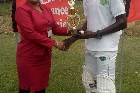 Kevlon Anderson (right) receives his man of the match prize from Hand In Hand representative Sarita Mohabir