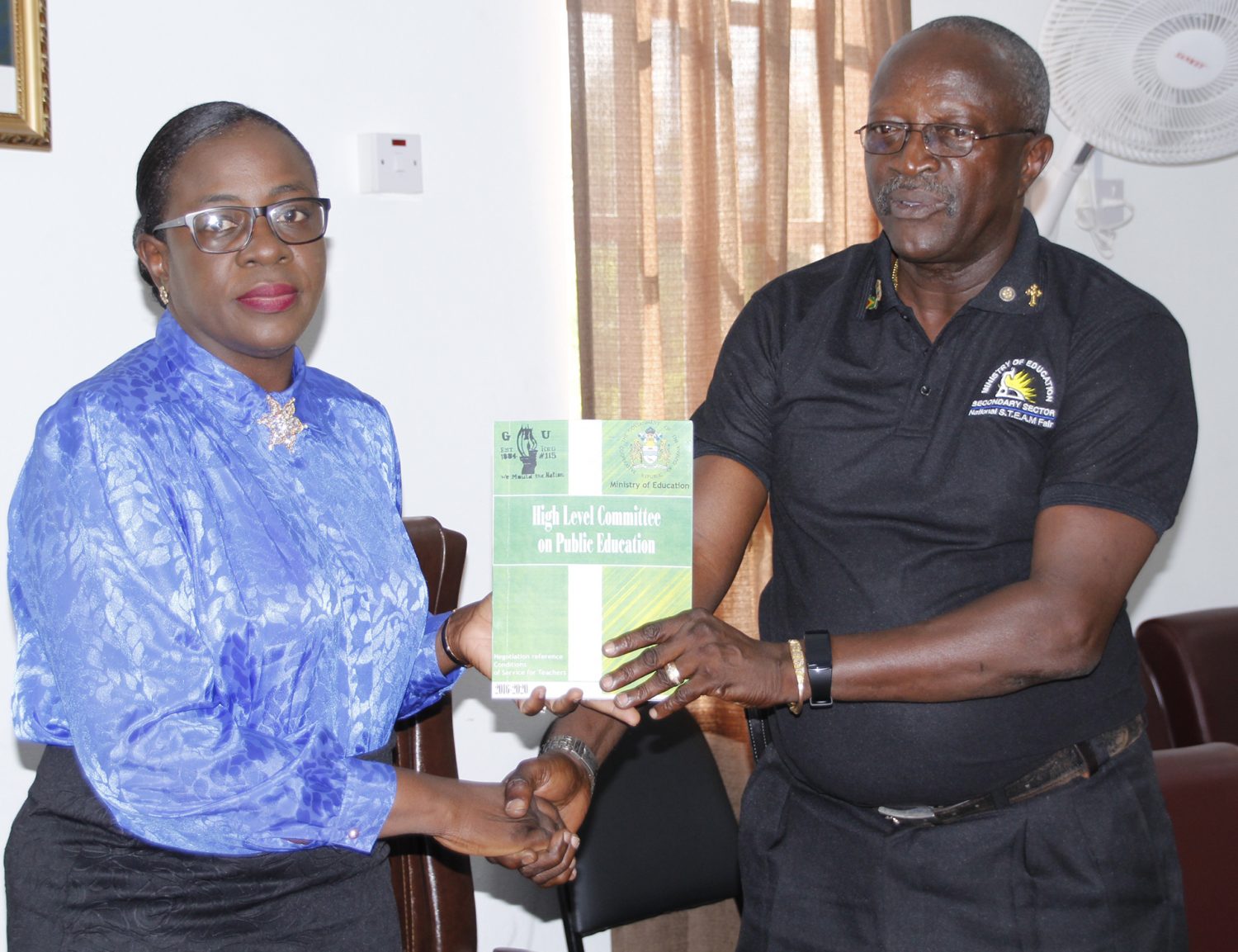 Minister of Education Nicolette Henry receives the task force’s report from Permanent Secretary of the Ministry of Education Vibert Welch (Department of Public Information Photo)