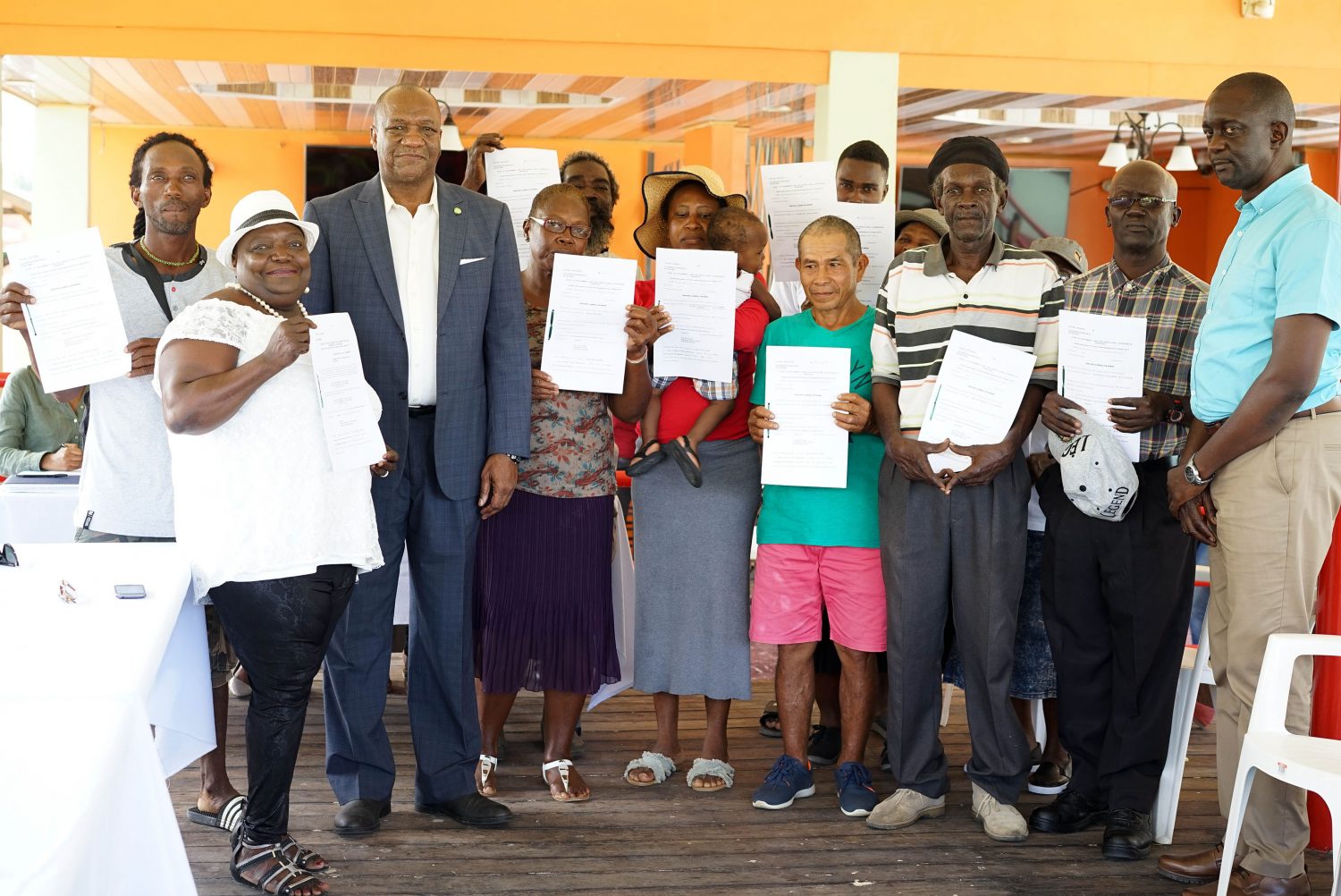 Minister of State Joseph Harmon (third from left) with the recipients.  Commissioner of the GLSC, Trevor Benn is at right. (Ministry of the Presidency photo)