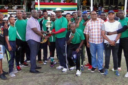 The Captain of the Presidential Guard team receives the winning team trophy from Assistant Commissioner of Police Nigel Hoppie.